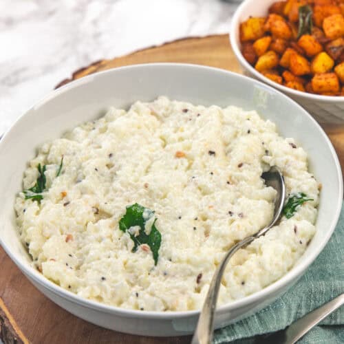 Curd rice in a bowl with spoon.