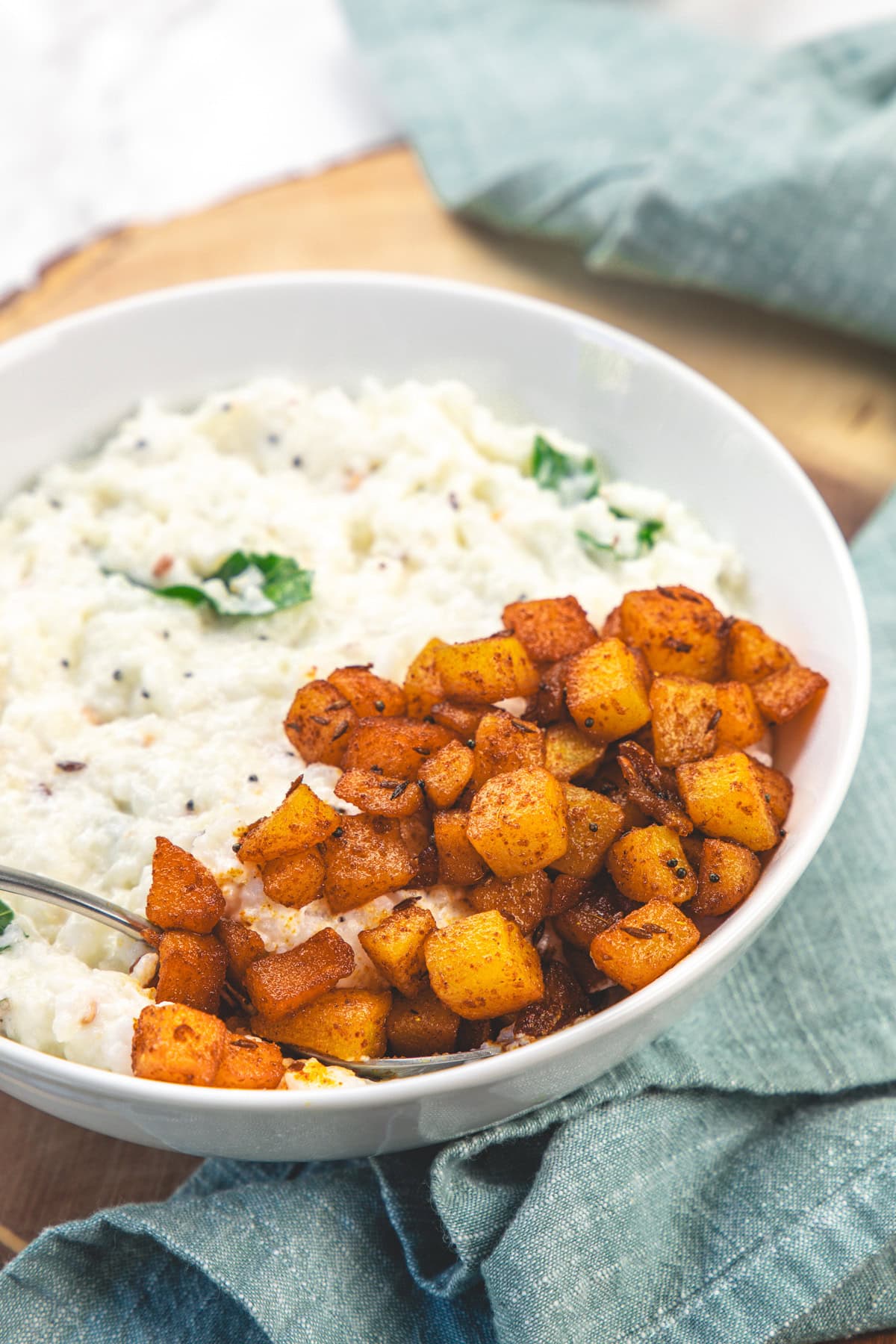 Aloo fry served with curd rice in a bowl.