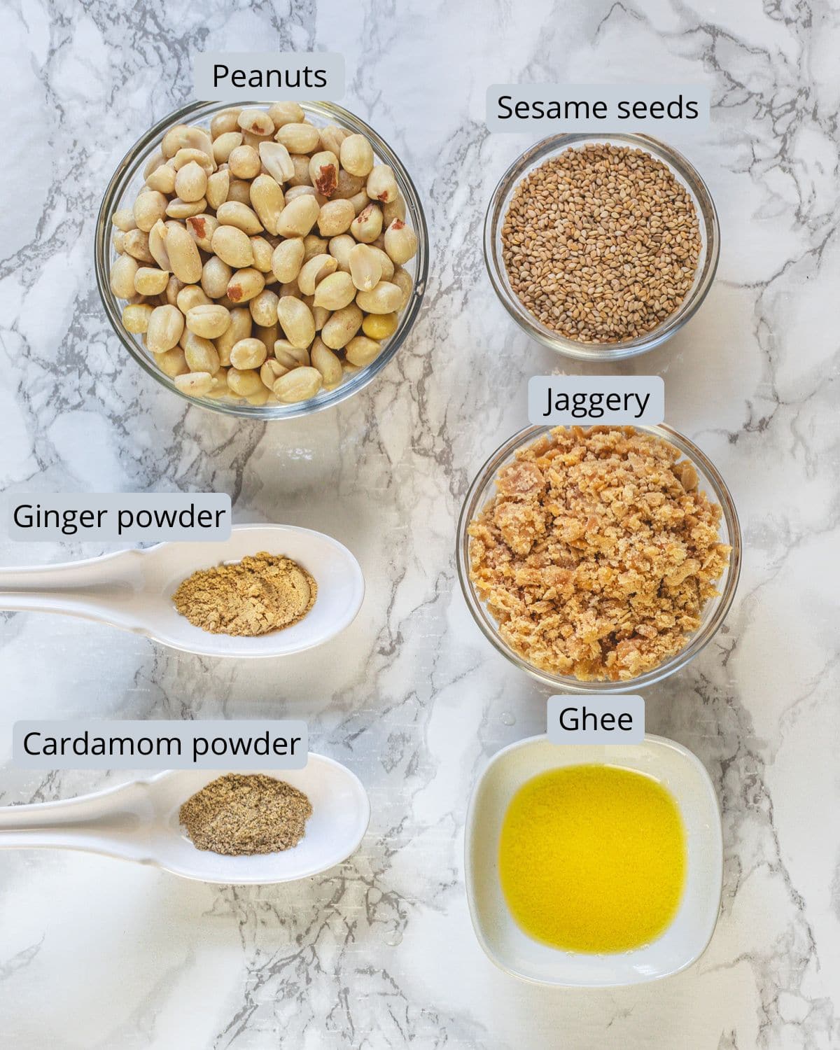Peanut ladoo ingredients in bowls and spoons with labels.
