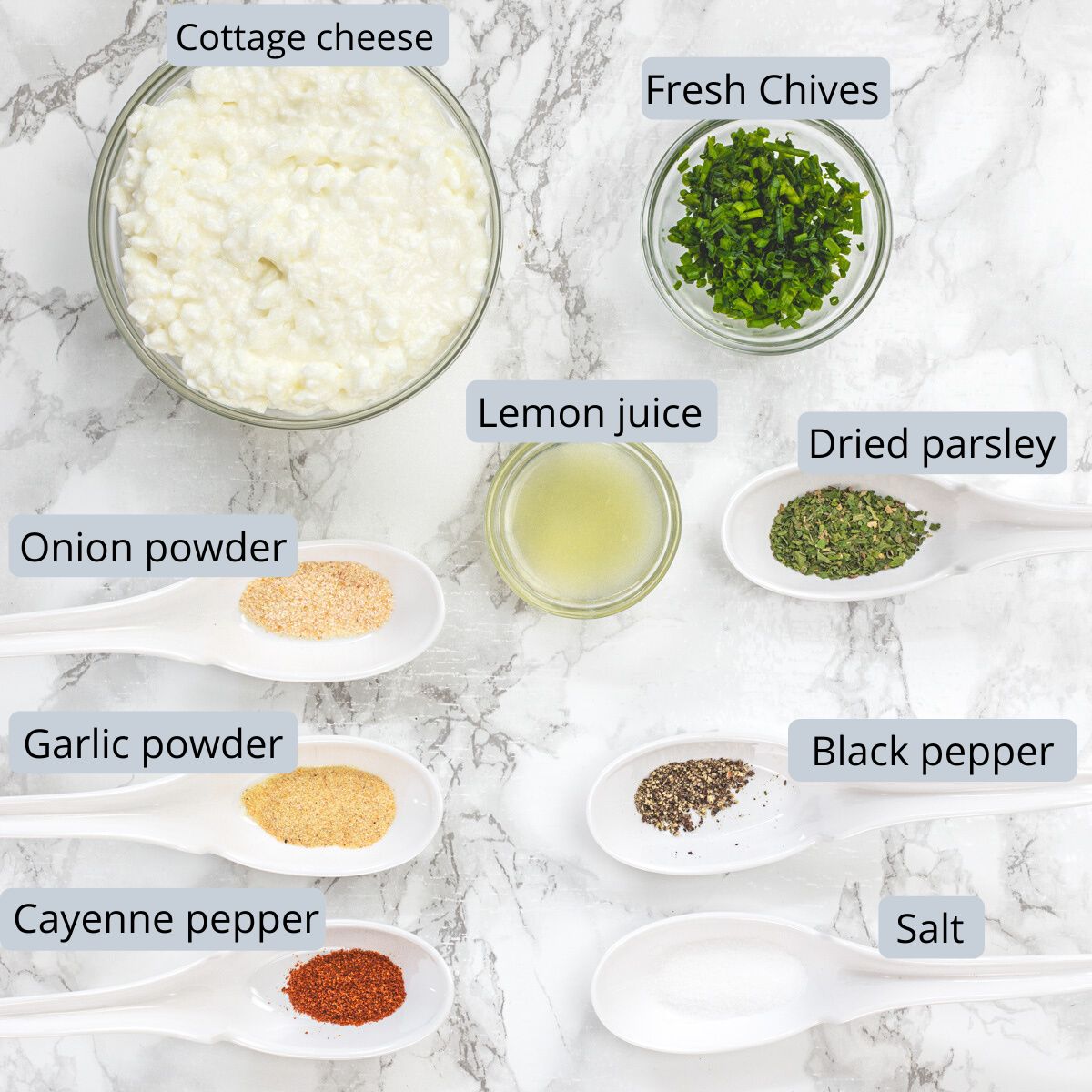Cottage cheese dip ingredients in bowls and spoons with labels.