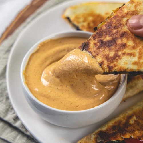 Dipping quesadilla into creamy jalapeno sauce.