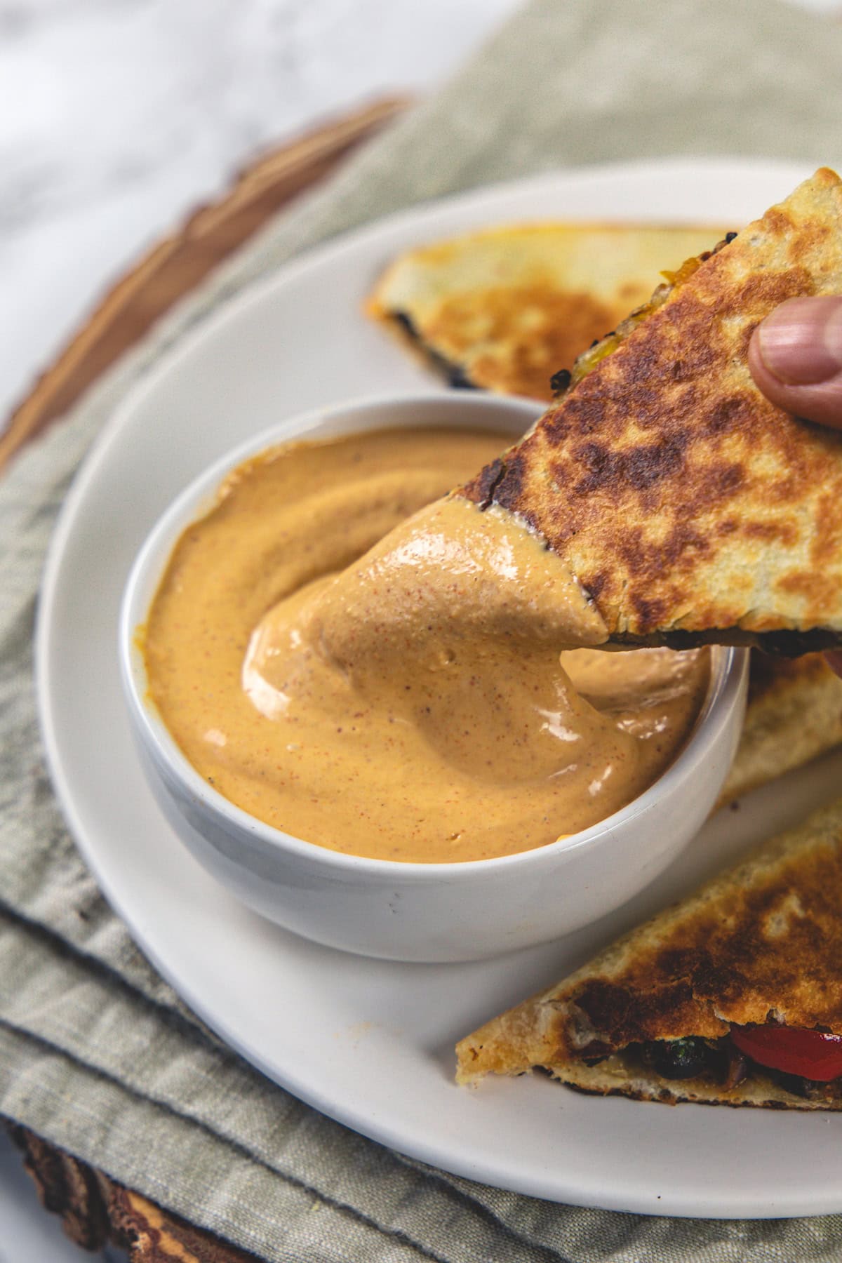 Dipping quesadilla into creamy jalapeno sauce.