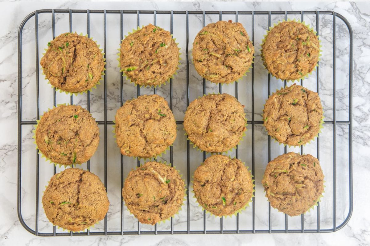 Eggless zucchini muffins cooling on a rack.
