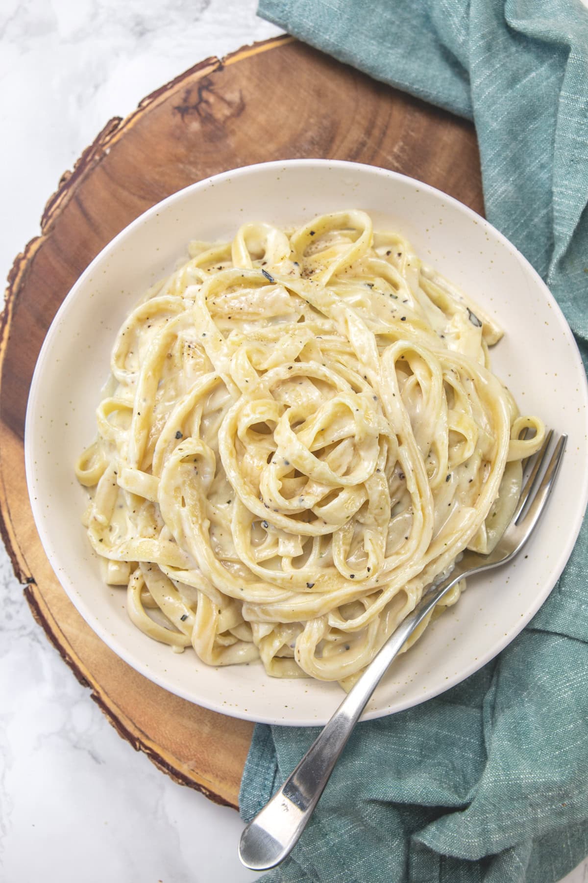 Copycat version of olive garden fettuccine alfredo in a plate with fork.