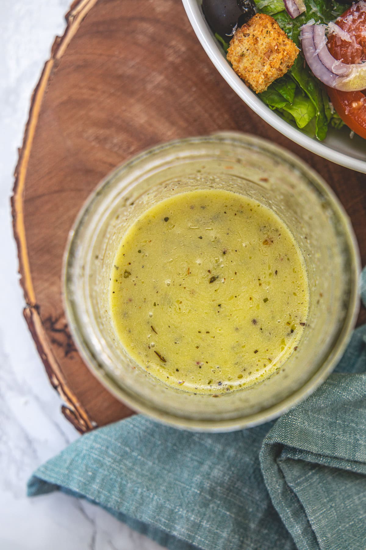 Olive Garden Salad Dressing in a mason jar that is on a wooden board.