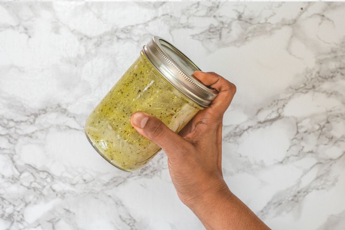 Shaking the jar to make salad dressing.