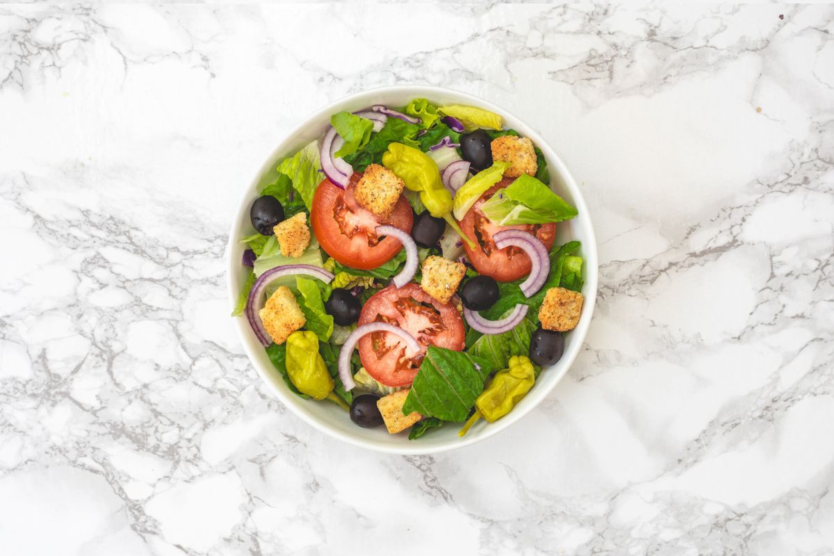 Salad ingredients are layered in a bowl.