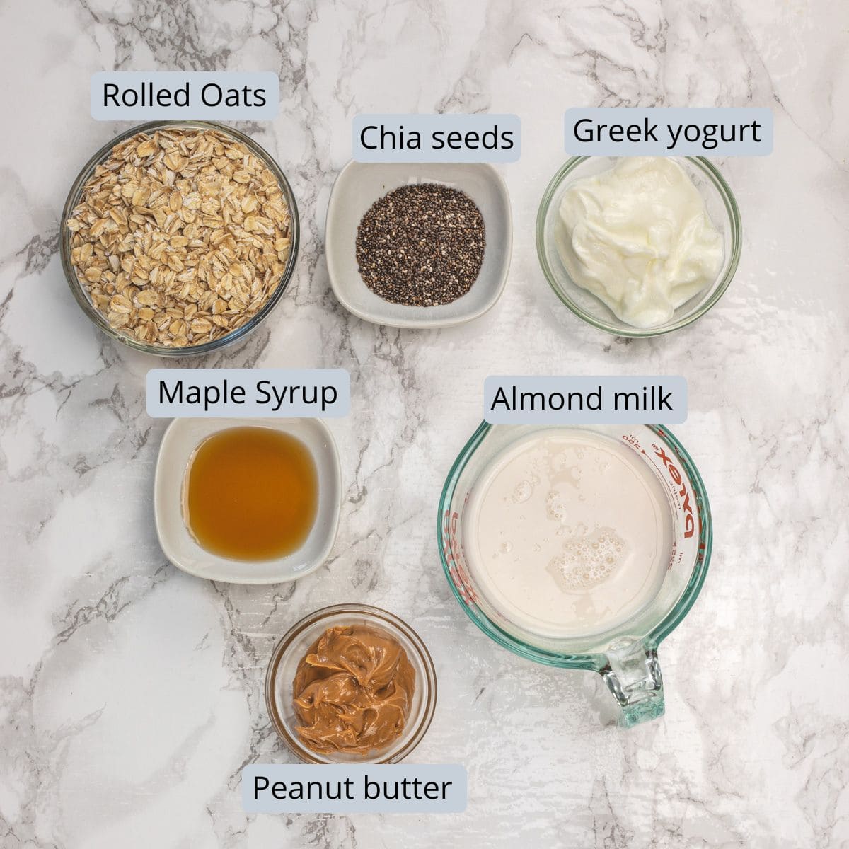 Peanut butter overnight oats ingredients in bowls with labels.