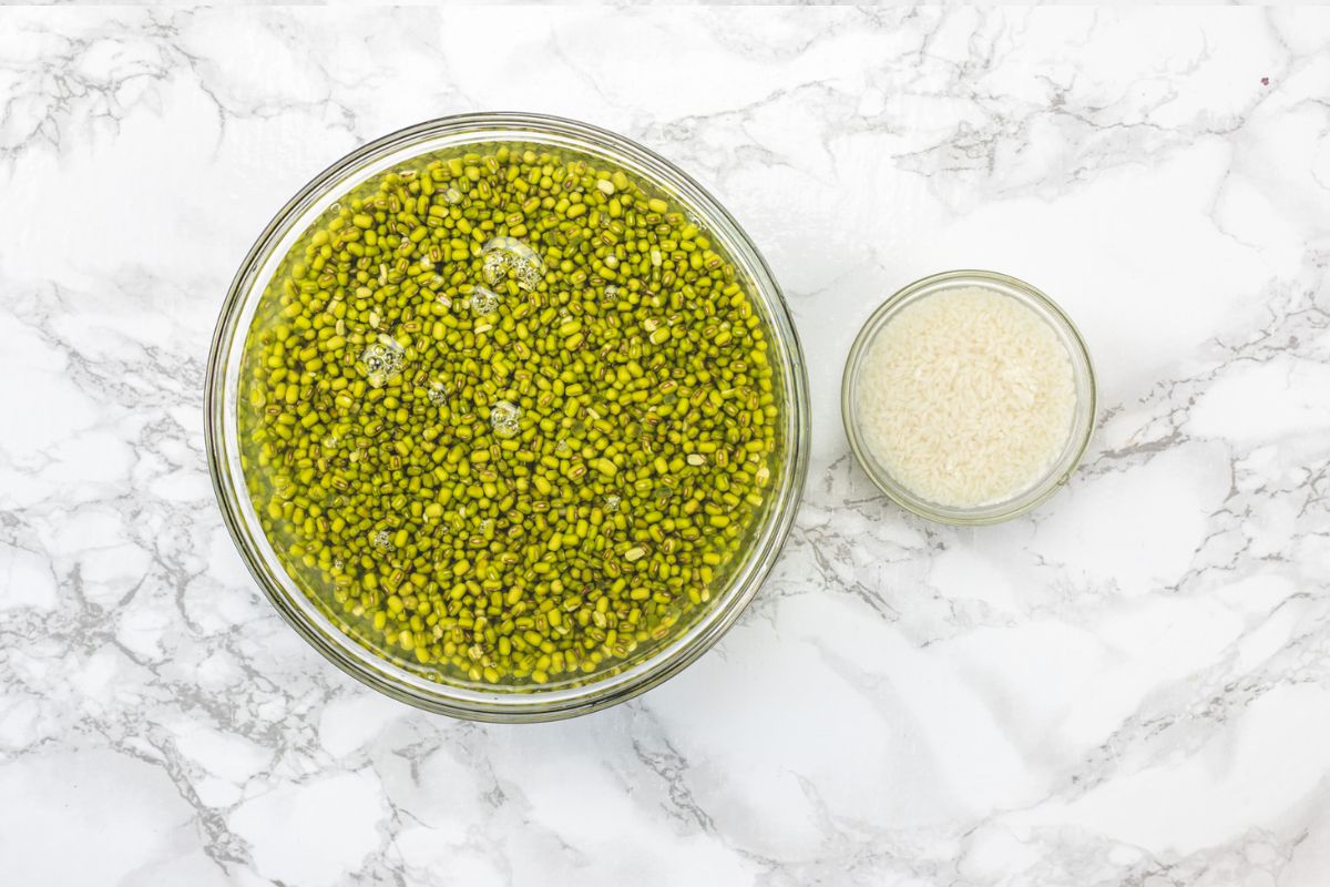 Soaked green moong and rice in separate bowls.