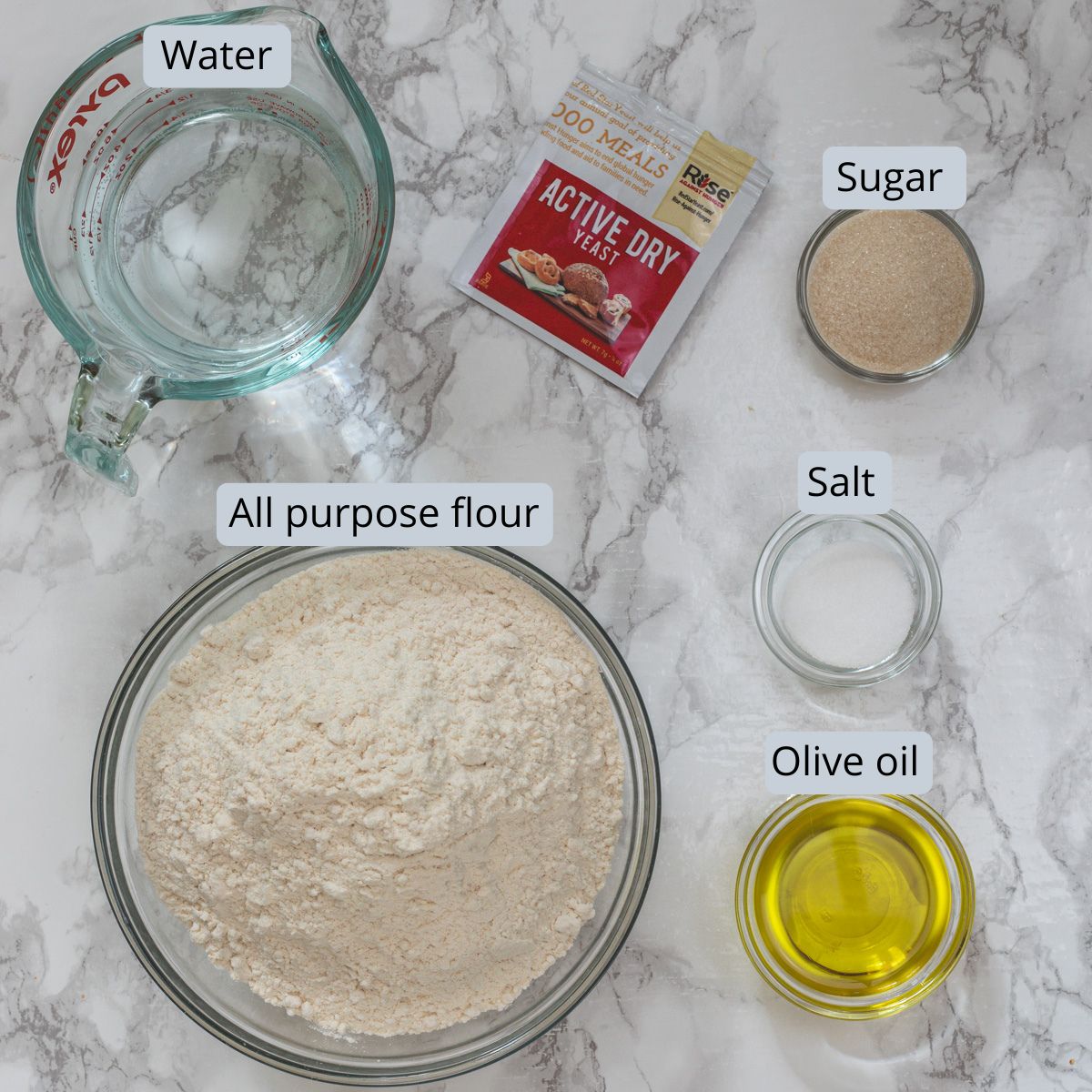 Copycat Olive Garden breadsticks ingredients in bowls and spoons with labels.