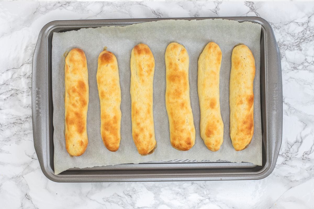 Baked olive garden style breadsticks in a baking tray.