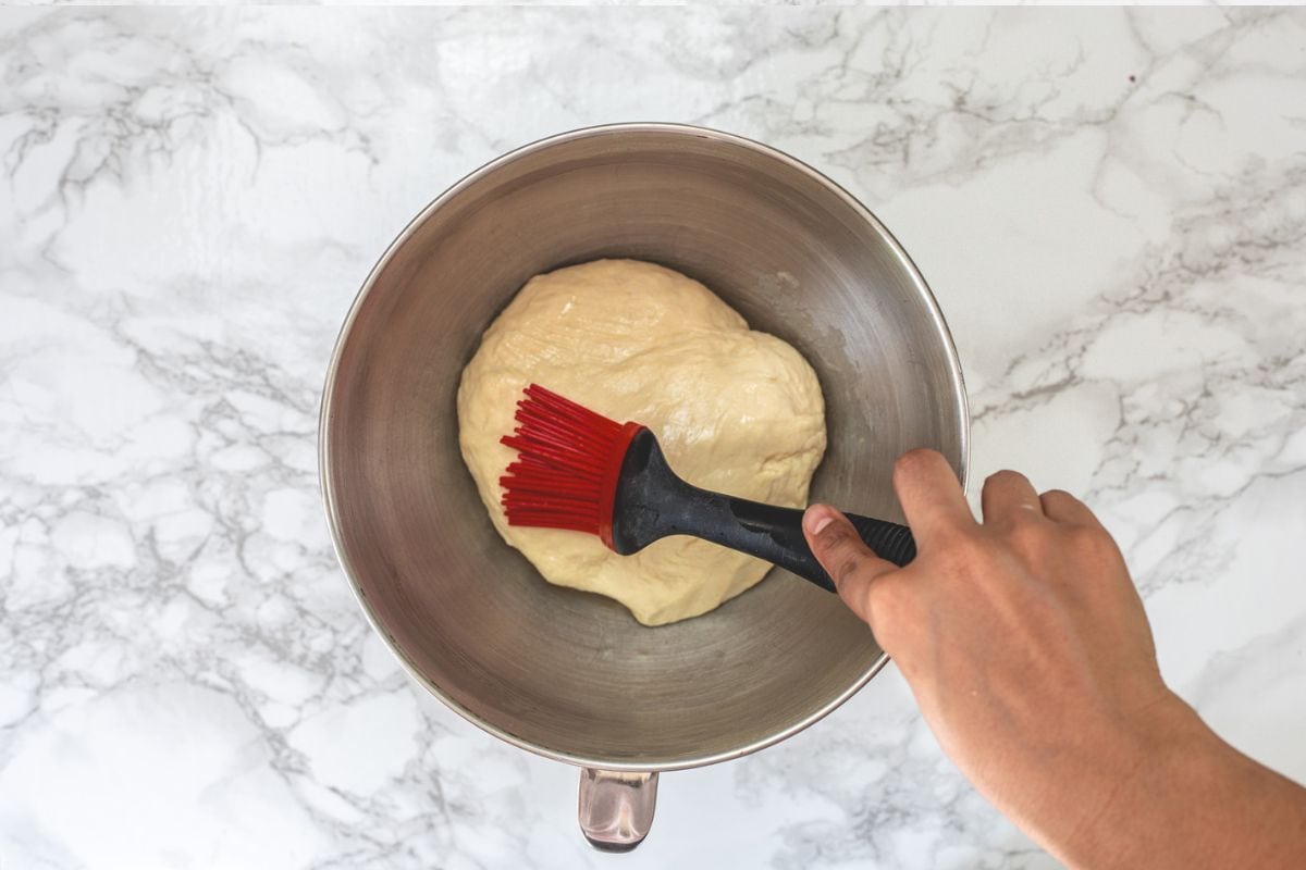 Brushing the dough with oil.